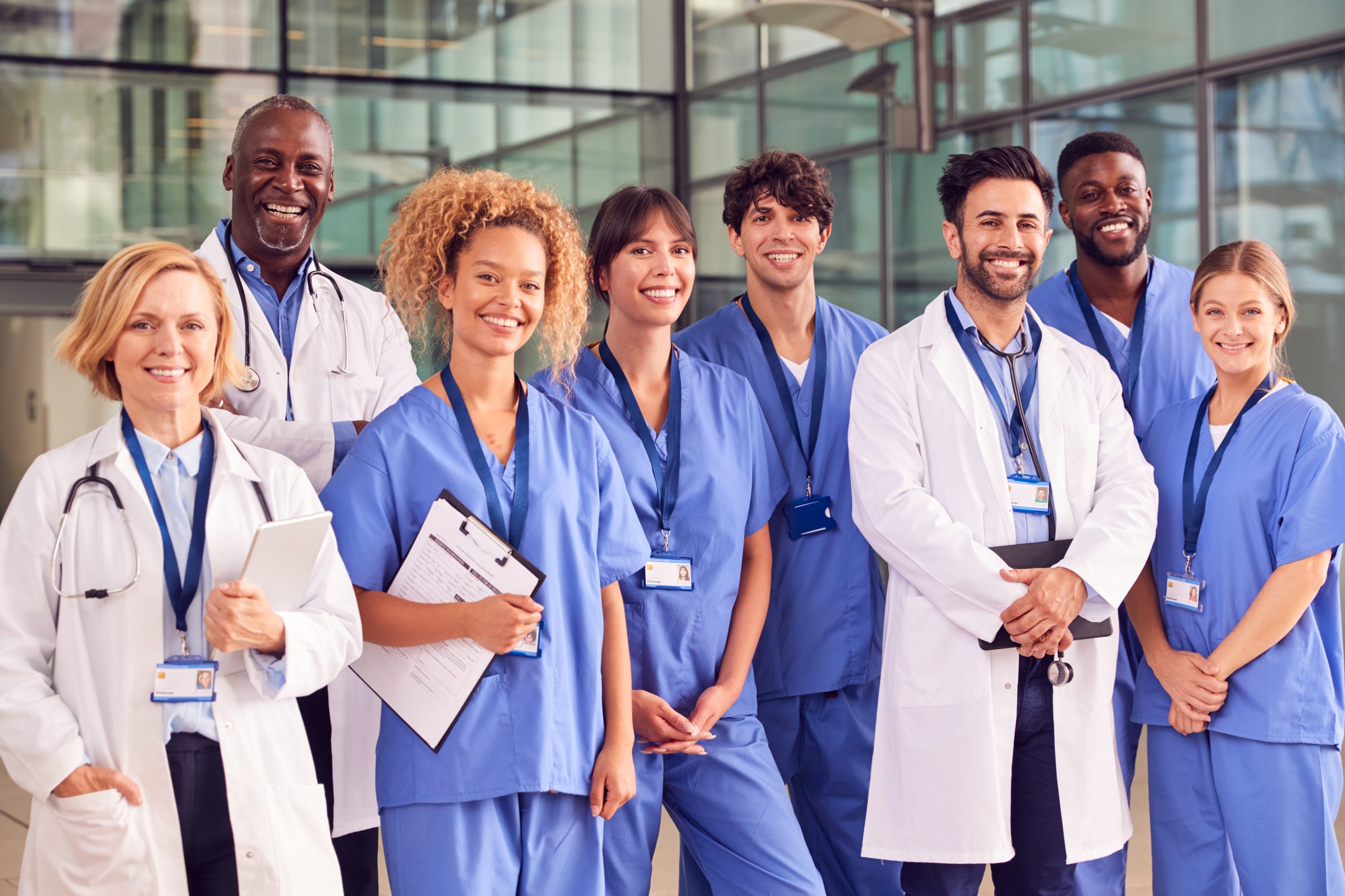 Smiling Medical Team Standing In Modern Hospital Building