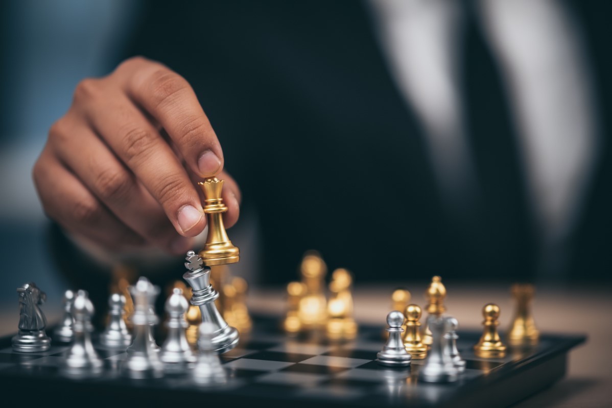 Hand of businessman moving chess figure in competition success play. strategy, management or leadership concept